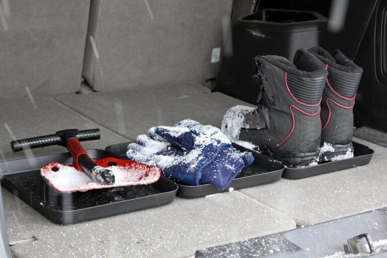 Snow covered shovel, gloves and boots placed on SubZero Customizable Boot Tray